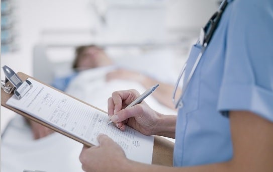 Enfermeira preenchenco ficha de anaminése